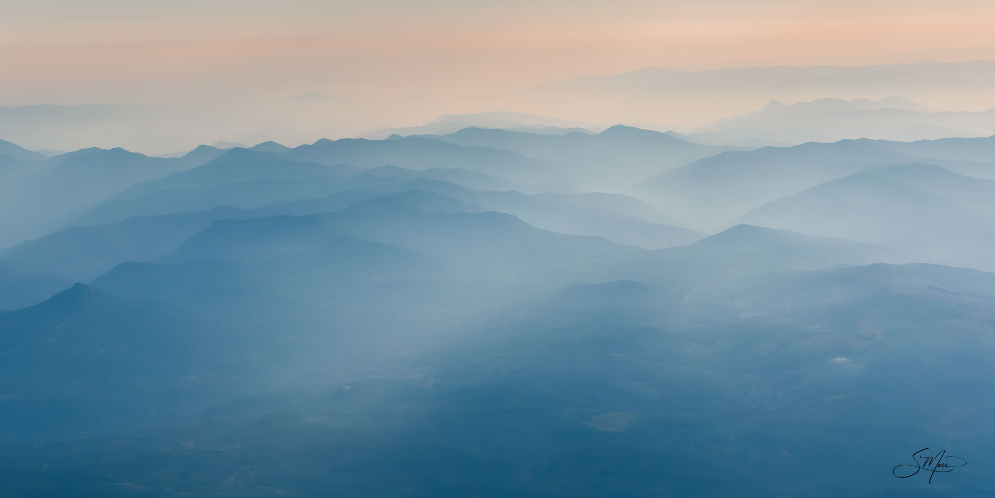 Morning Light Over the Cascade Mountain Range with Fog Settling between the Layers of mountains.
